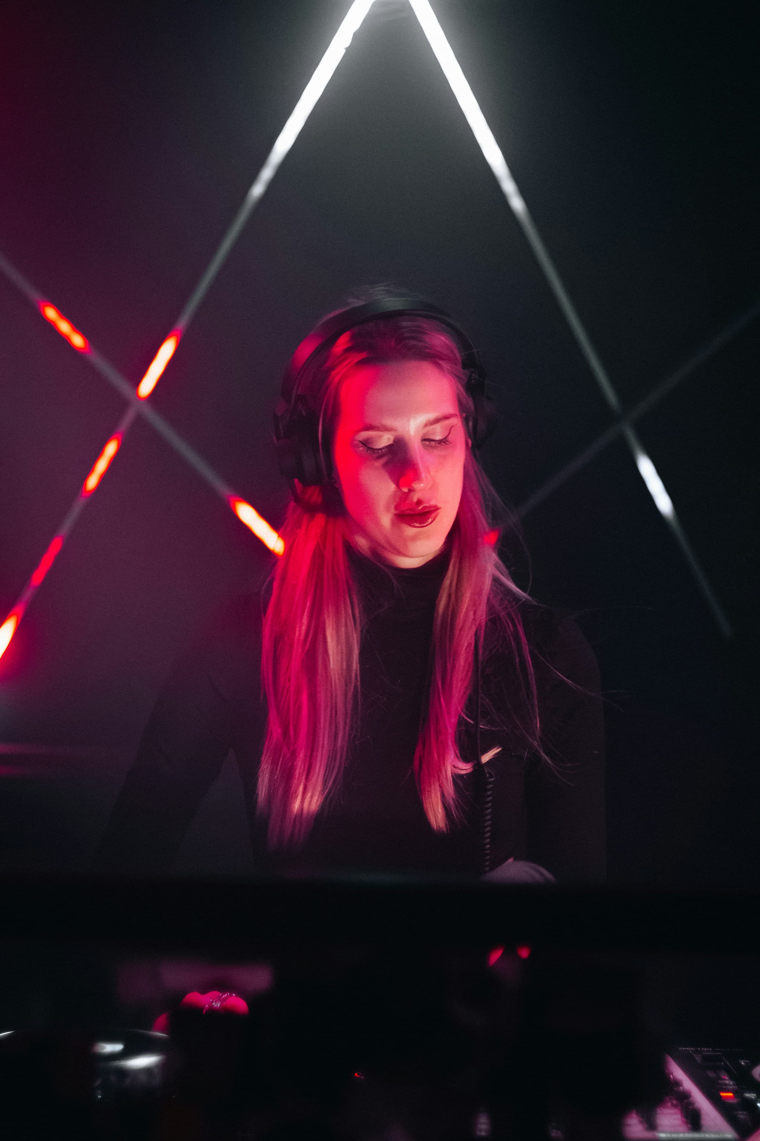 Mira Vale performing behind the decks under magenta lights